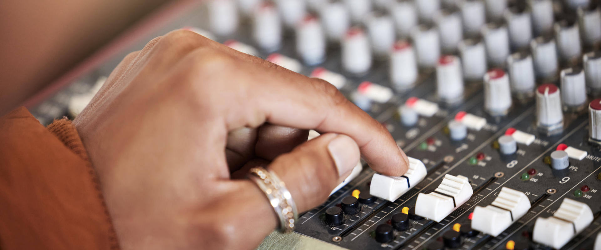 Person adjusting an audio mixer